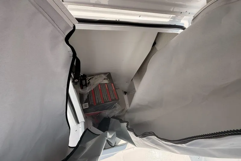 Slide: The Image of Storage compartment in 2026 Wellcraft 202 Fisherman boat, partially open with visible contents. - 20
