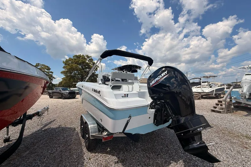 Slide: The Image of 2026 Wellcraft 202 Fisherman boat with Mercury engine on trailer under blue sky. - 3