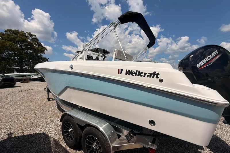 Slide: The Image of 2026 Wellcraft 202 Fisherman boat on trailer, featuring Mercury outboard motor, under blue sky. - 4
