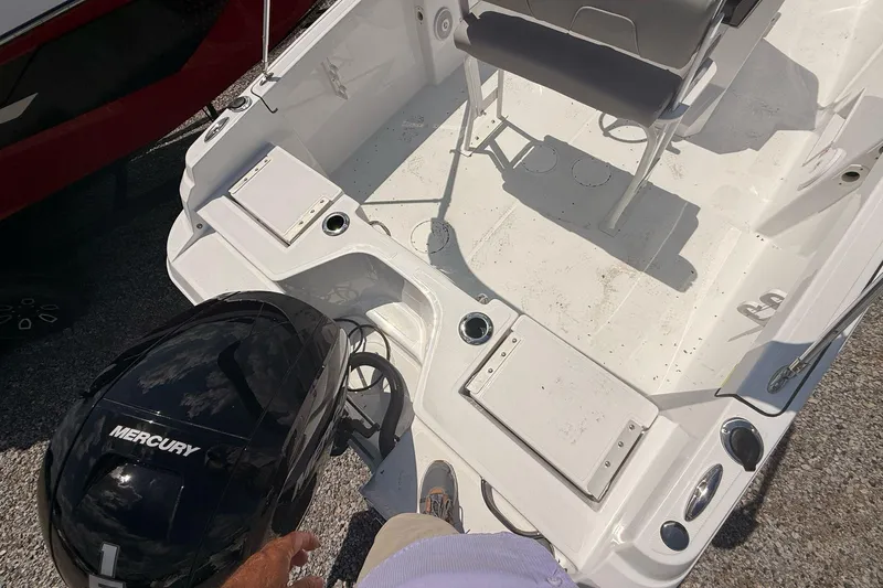 Slide: The Image of 2026 Wellcraft 202 Fisherman boat interior with Mercury engine, featuring seating and storage compartments. - 7