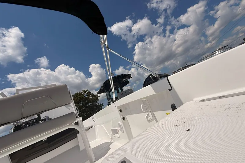 Slide: The Image of 2026 Wellcraft 202 Fisherman boat interior under a bright blue sky with clouds. - 8