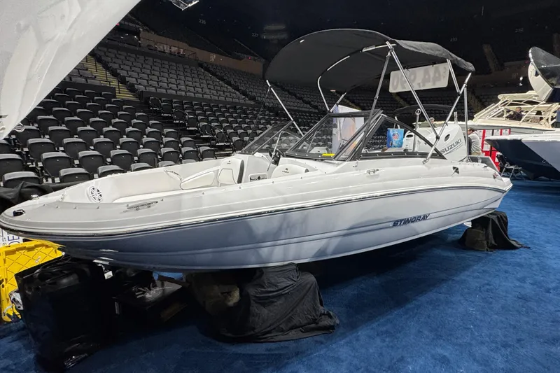 The Image of 2026 Stingray 191 DC boat displayed indoors with seating and canopy. - 1