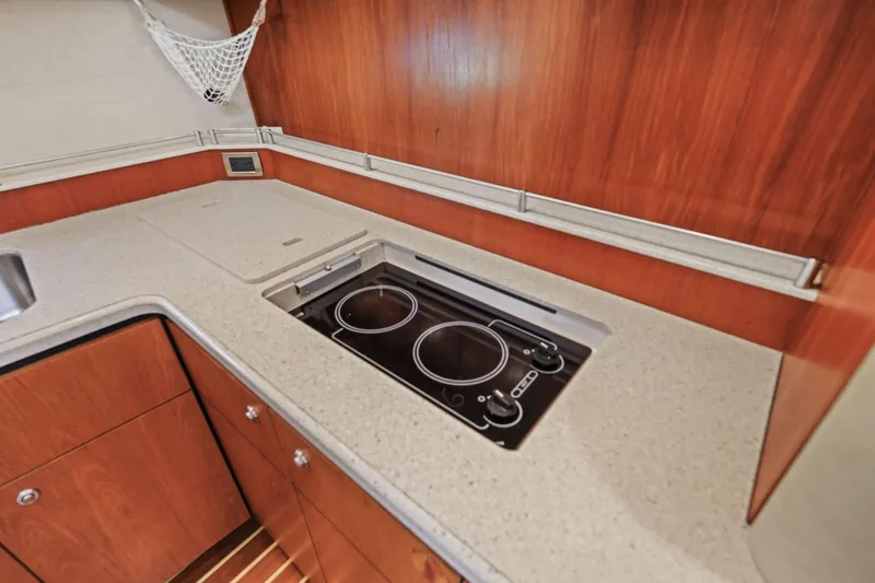 Slide: The Image of 2008 Tiara Yachts 4300 Sovran kitchen with sleek cooktop and wooden cabinetry. - 14