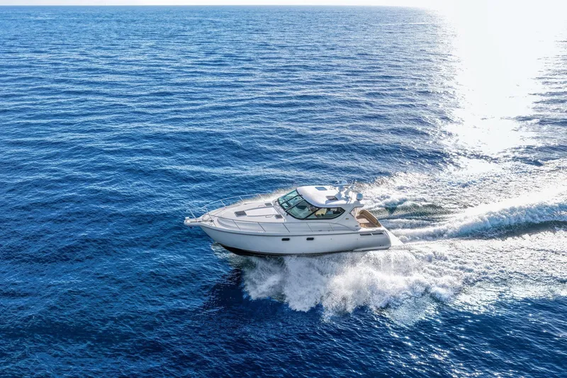 Slide: The Image of 2008 Tiara Yachts 4300 Sovran cruising on open blue sea under bright sunlight. - 2
