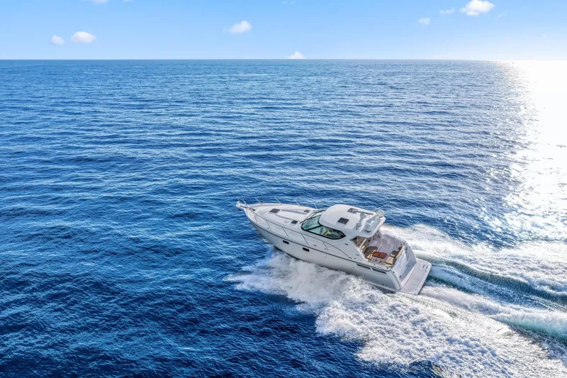 Slide: The Image of 2008 Tiara Yachts 4300 Sovran cruising on open blue ocean under clear sky. - 3