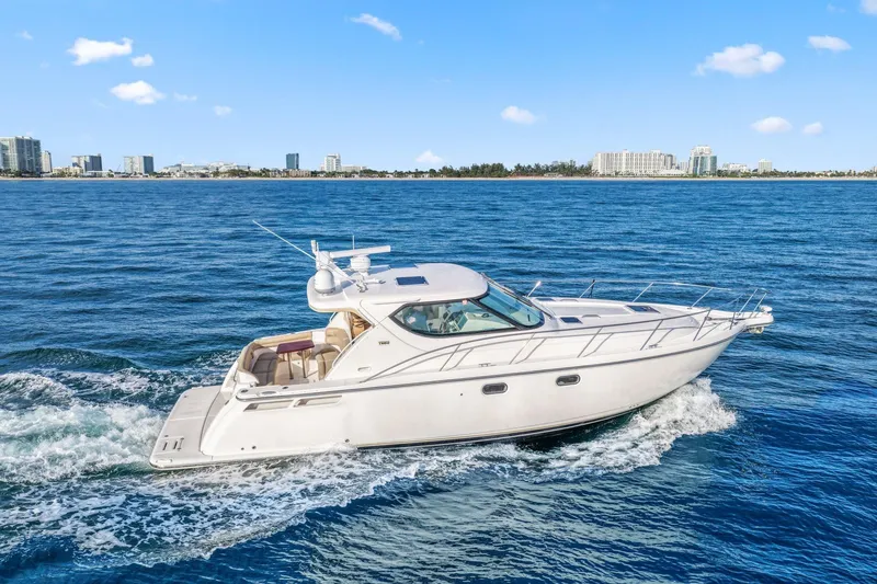 Slide: The Image of 2008 Tiara Yachts 4300 Sovran cruising on blue ocean near city skyline. - 5