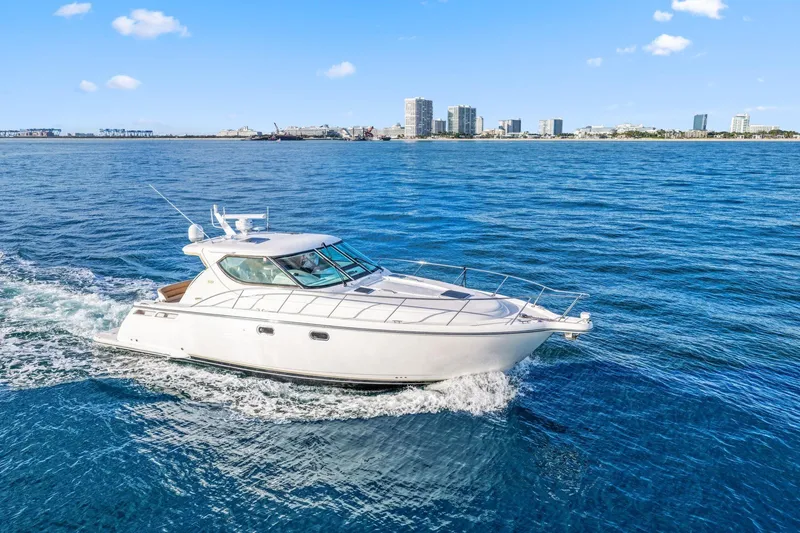 Slide: The Image of 2008 Tiara Yachts 4300 Sovran cruising on blue ocean near city skyline. - 8
