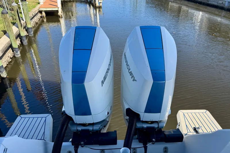Slide: The Image of Twin Mercury outboard engines on a 2025 Intrepid 327 Cuddy boat, docked in calm waters. - 10