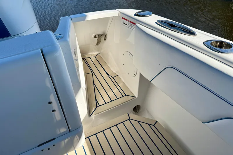 Slide: The Image of 2025 Intrepid 327 Cuddy boat interior with sleek white design and striped flooring. - 26