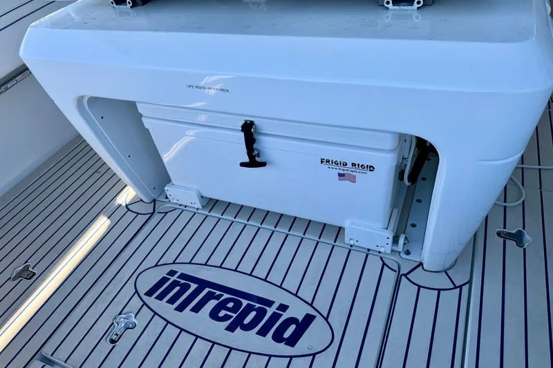 Slide: The Image of 2025 Intrepid 327 Cuddy boat deck with Frigid Rigid cooler and branded flooring. - 27