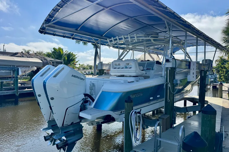 Slide: The Image of 2025 Intrepid 327 Cuddy boat with dual Mercury engines on a lift. - 3