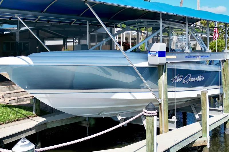 Slide: The Image of 2025 Intrepid 327 Cuddy boat docked under a blue canopy. - 33