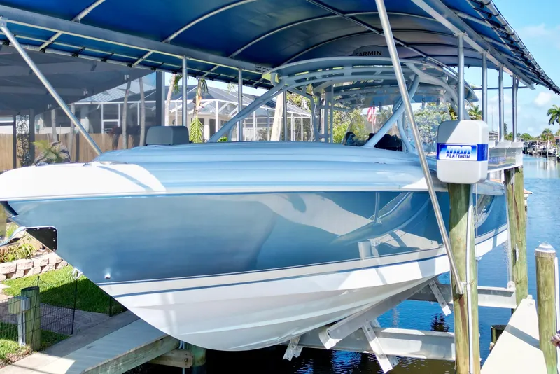 Slide: The Image of 2025 Intrepid 327 Cuddy boat docked under a canopy in a marina. - 34