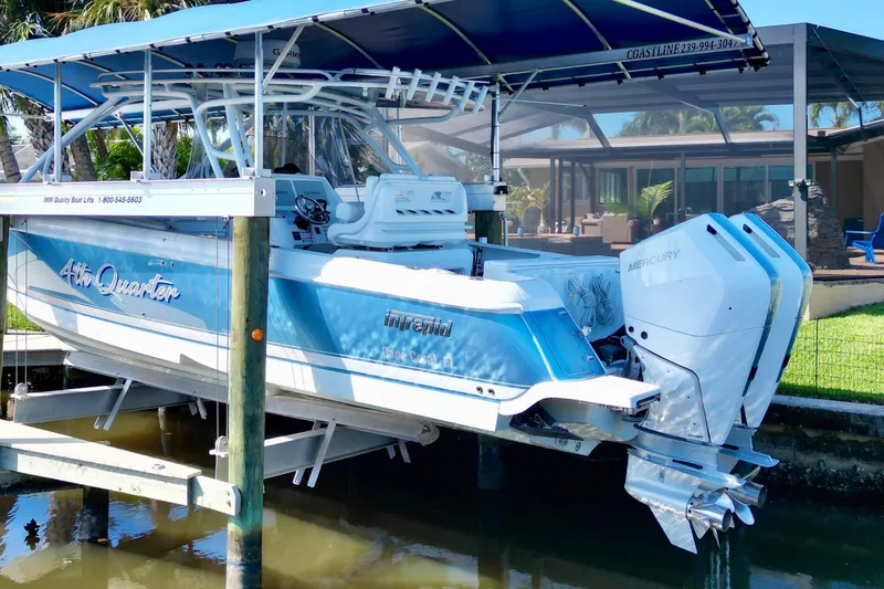 Slide: The Image of 2025 Intrepid 327 Cuddy boat with dual Mercury engines on a lift. - 38