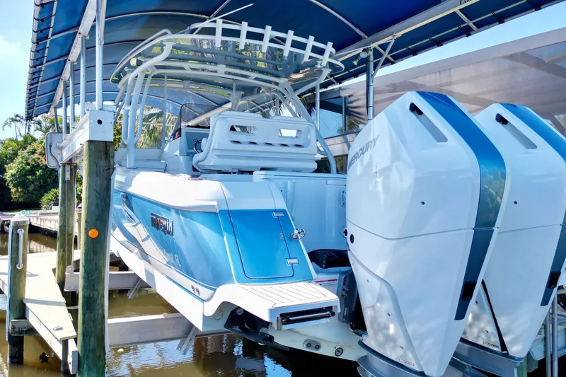 Slide: The Image of 2025 Intrepid 327 Cuddy boat with dual Mercury engines on a lift. - 41