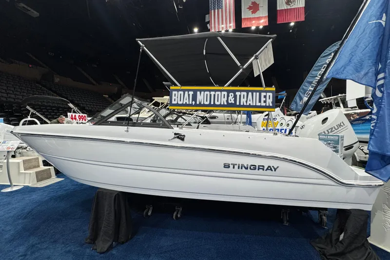 Slide: The Image of 2026 Stingray 172 DC boat displayed at a boat show with promotional signage. - 8