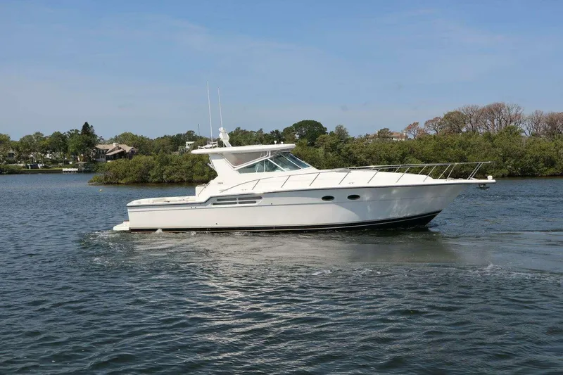 The Image of 2001 Tiara Yachts 4300 Open cruising on a serene lake with lush greenery. - 0