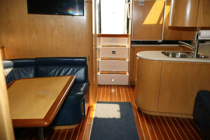 Slide: The Image of Interior of 2001 Tiara Yachts 4300 Open with wood finish and compact kitchen. - 12