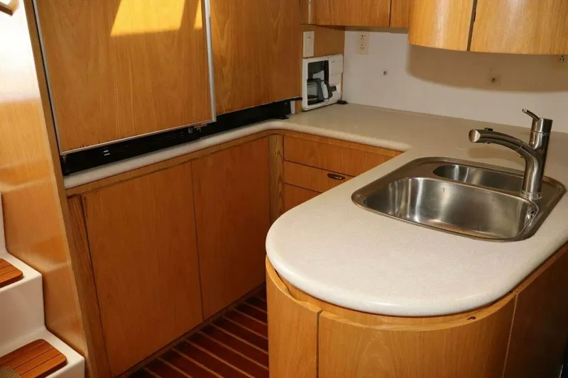 Slide: The Image of 2001 Tiara Yachts 4300 Open kitchen with wooden cabinetry and stainless steel sink. - 13