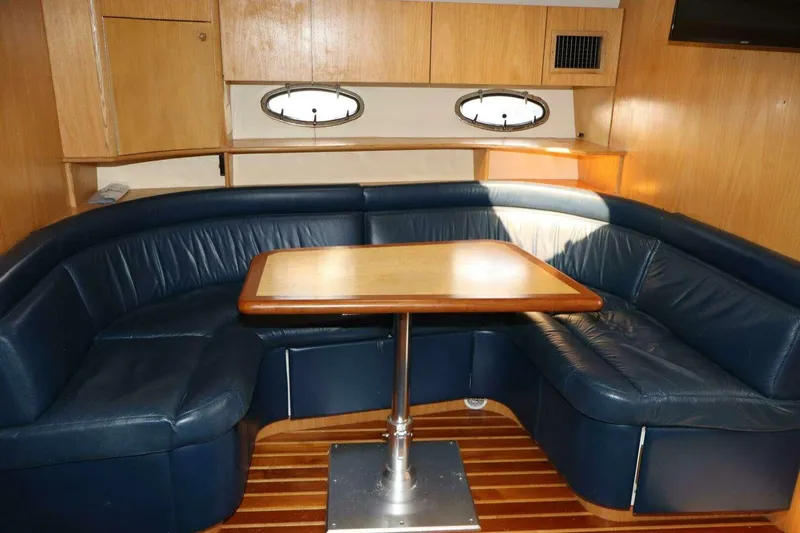 Slide: The Image of 2001 Tiara Yachts 4300 Open interior with blue leather seating and wooden table. - 15