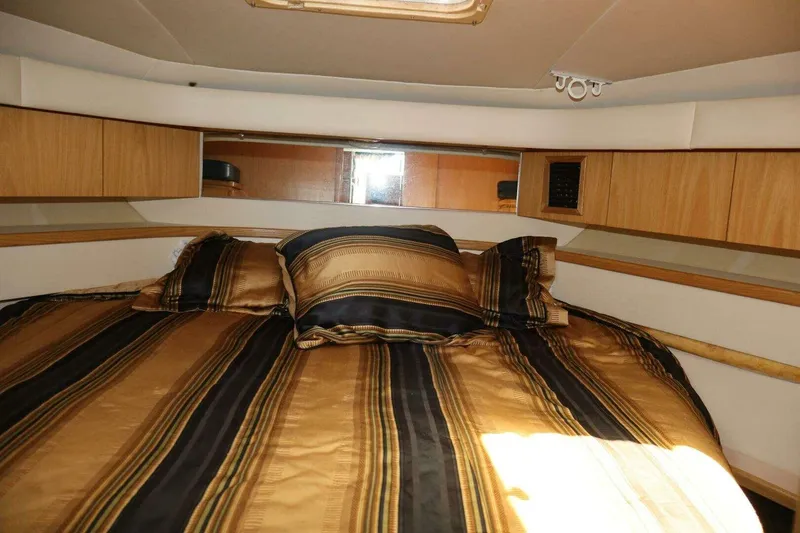 Slide: The Image of Luxurious cabin interior of 2001 Tiara Yachts 4300 Open with striped bedding. - 16