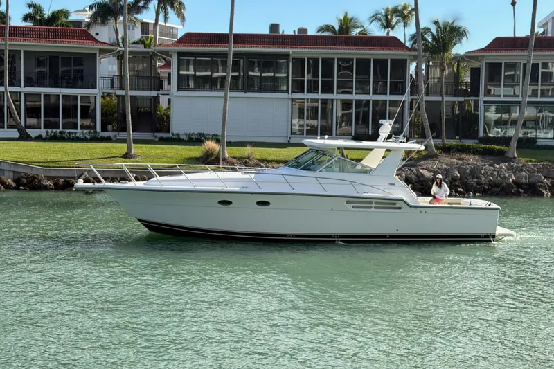 Slide: The Image of 2001 Tiara Yachts 4300 Open cruising near waterfront homes with palm trees. - 4