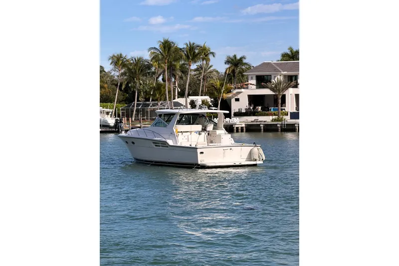 Slide: The Image of 2001 Tiara Yachts 4300 Open on water near palm trees and luxury homes. - 5