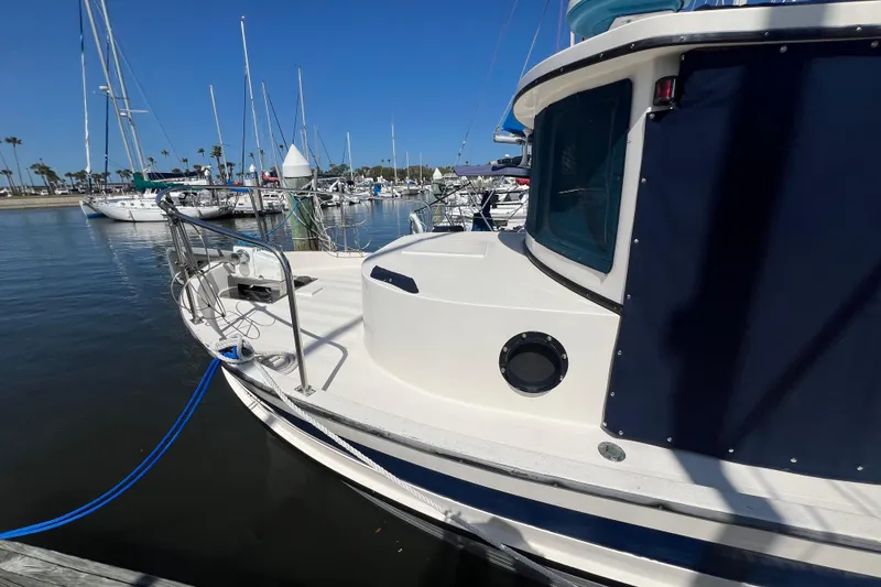 Slide: The Image of 1993 Nordic Tug 26 docked at marina, showcasing classic design and blue accents. - 10