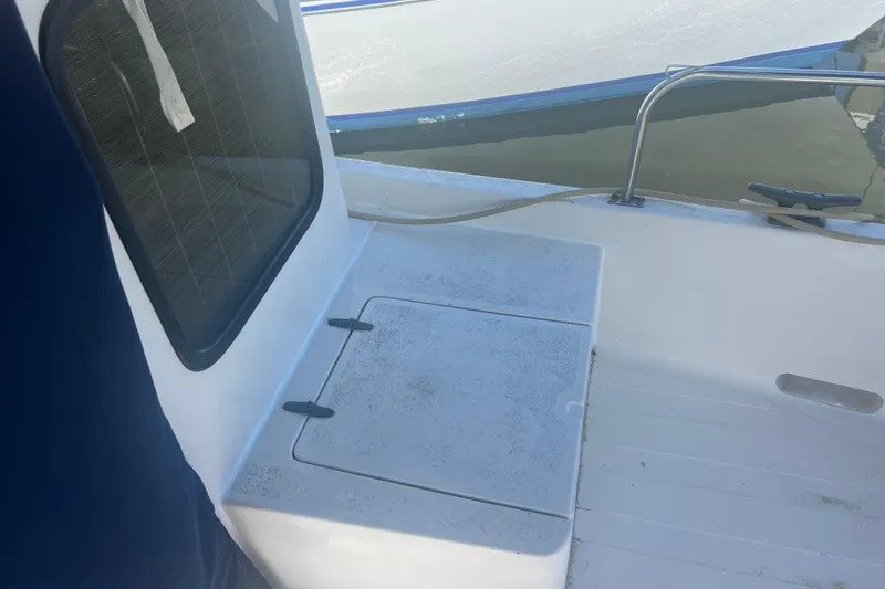 Slide: The Image of Open hatch on 1993 Nordic Tug 26 boat deck, revealing interior compartment. - 13