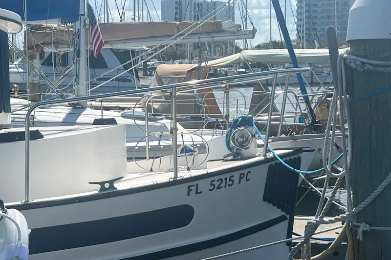 Slide: The Image of 1993 Nordic Tug 26 docked at marina, surrounded by sailboats under clear blue sky. - 2