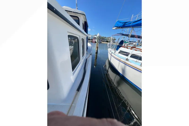 Slide: The Image of Nordic Tug 26 (1993) docked beside a sailboat in a marina. - 22