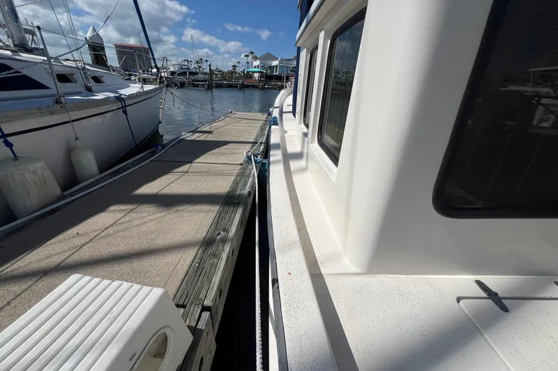Slide: The Image of Wooden cabin door on a 1993 Nordic Tug 26 boat, featuring glass panels. - 23