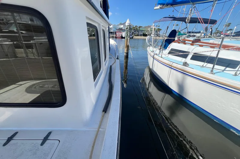 Slide: The Image of Interior view of 1993 Nordic Tug 26 with open wooden doors and seating area. - 24