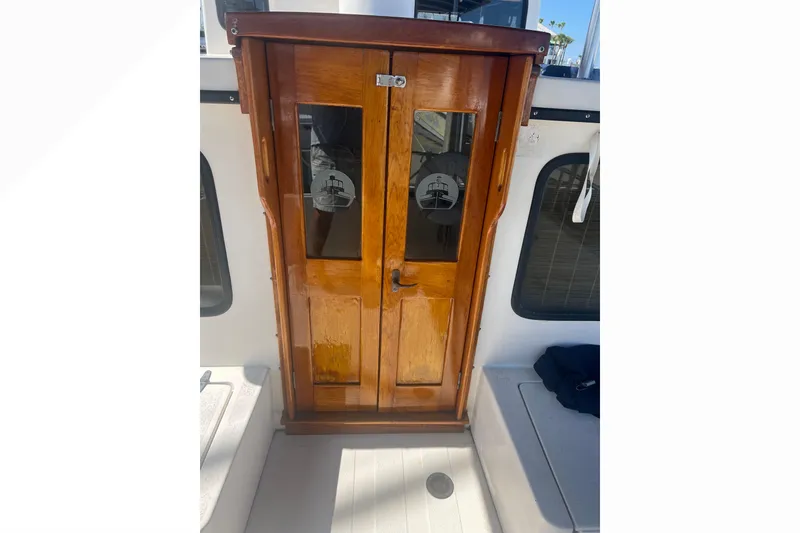 Slide: The Image of Cozy interior of a 1993 Nordic Tug 26 with blue seating and wooden accents. - 25