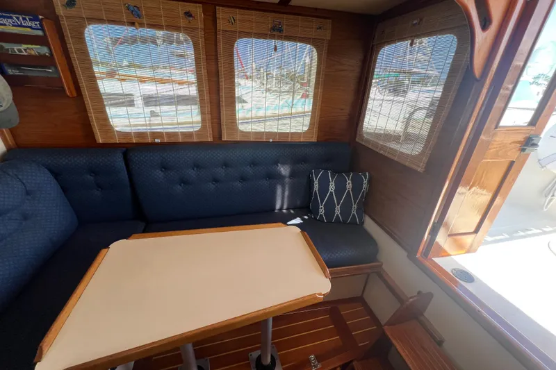 Slide: The Image of Interior of a 1993 Nordic Tug 26 with wooden accents and blue seating. - 28