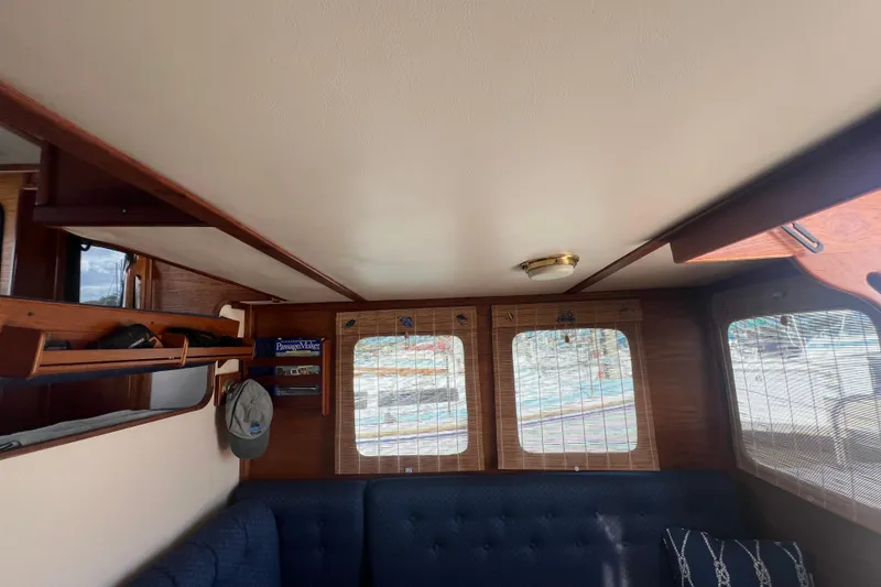 Slide: The Image of 1993 Nordic Tug 26 kitchen area with sink, microwave, and wooden cabinetry. - 30