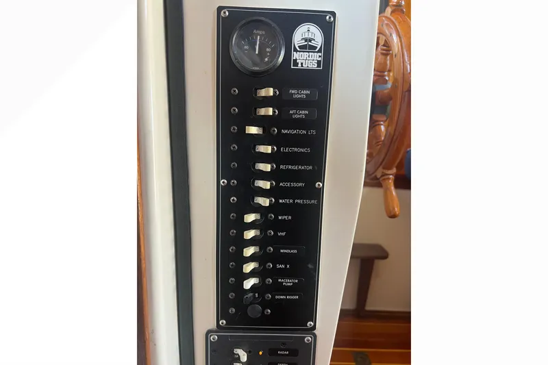 Slide: The Image of Electrical panel of a 1993 Nordic Tug 26 boat with labeled switches. - 47