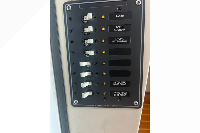Slide: The Image of Control panel of a 1993 Nordic Tug 26 boat with labeled switches. - 48