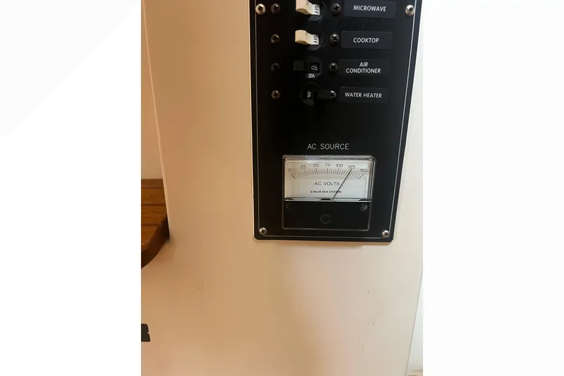 Slide: The Image of Control panel of a 1993 Nordic Tug 26 with AC voltage meter and switches. - 49