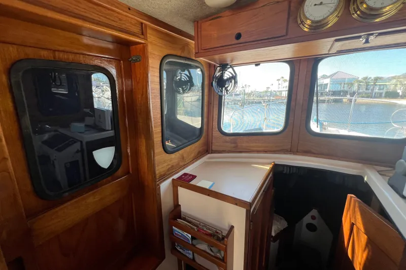 Slide: The Image of Interior of a 1993 Nordic Tug 26 with wood accents and nautical clock. - 60
