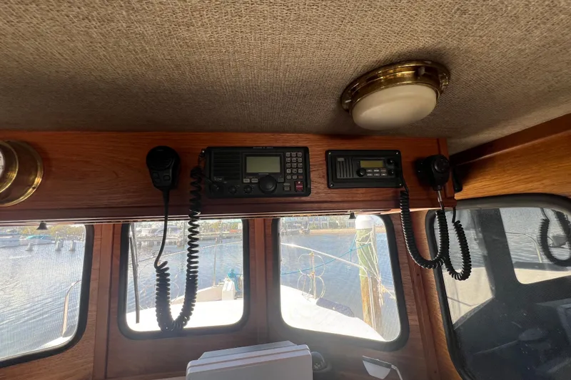 Slide: The Image of Interior of 1993 Nordic Tug 26 with wooden helm and blue seating. - 62