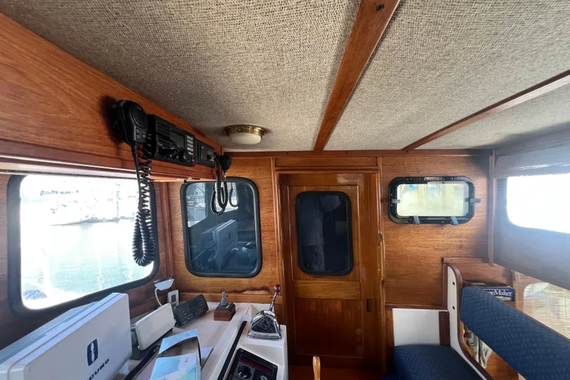 Slide: The Image of Engine compartment of a 1993 Nordic Tug 26, showcasing mechanical components and wiring. - 65