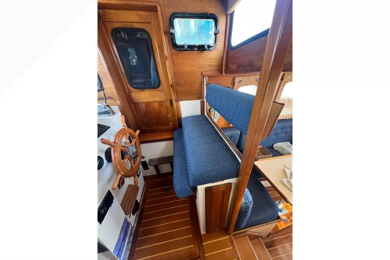 Slide: The Image of Cozy cabin interior of 1993 Nordic Tug 26 with striped pillows and wooden cabinet. - 66