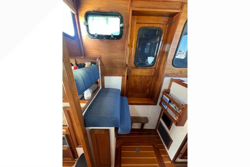 Slide: The Image of Cozy sleeping area in a 1993 Nordic Tug 26 boat with striped bedding. - 67