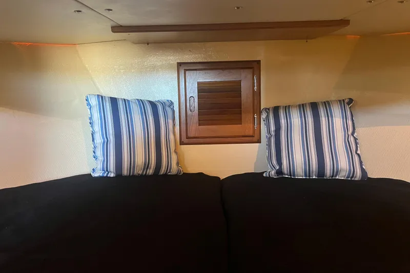 Slide: The Image of Interior of a 1993 Nordic Tug 26, featuring a wooden vented cabinet and cozy bedding. - 70