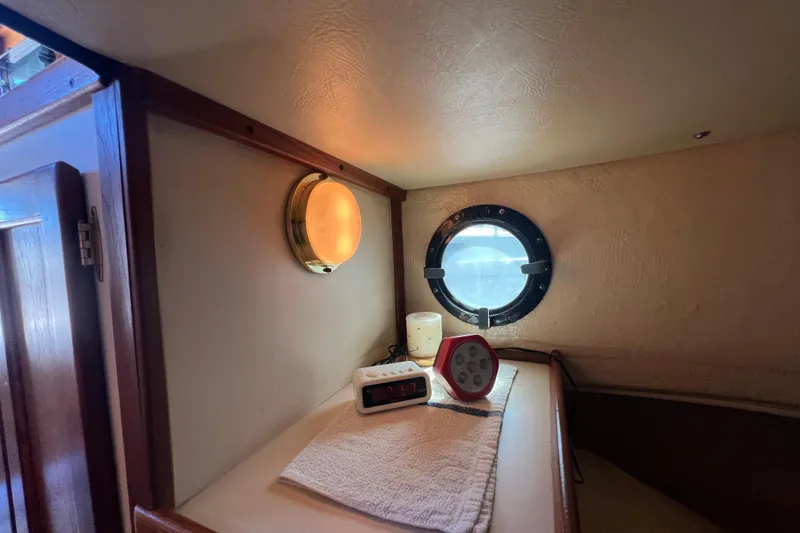Slide: The Image of Interior of 1993 Nordic Tug 26, featuring wooden cabinetry and cozy sleeping area. - 74