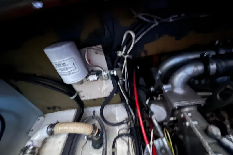 Slide: The Image of Engine compartment of a 1993 Nordic Tug 26 with visible hoses and components. - 94