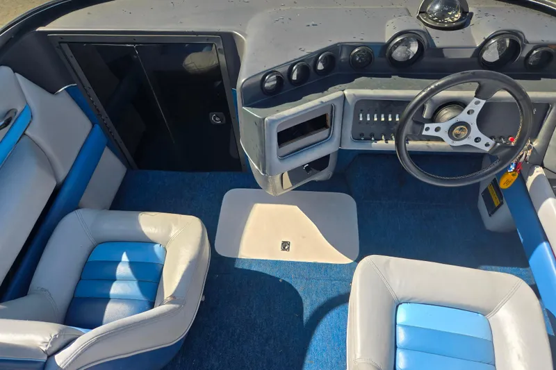 Slide: The Image of Interior of a 1987 Sea Ray Pachanga 22 boat with blue and white seating. - 11