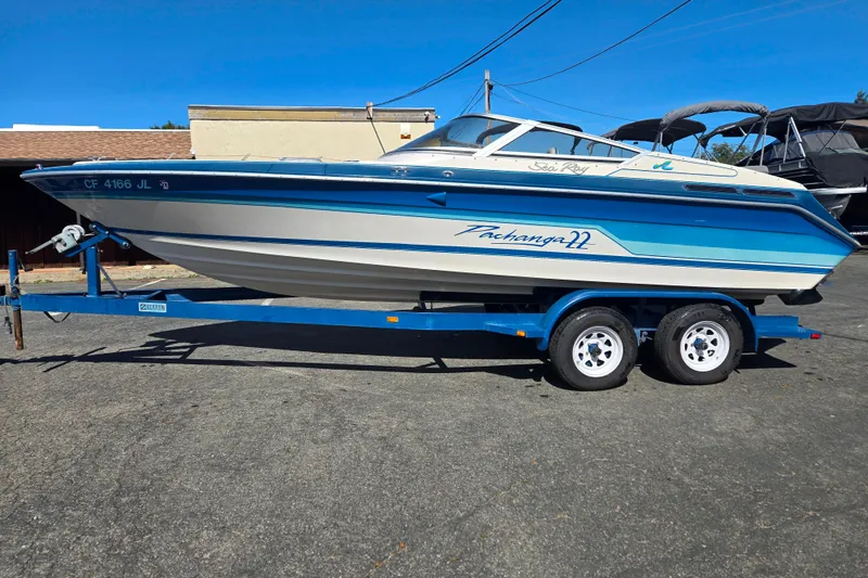 Slide: The Image of 1987 Sea Ray Pachanga 22 boat on trailer, blue and white design, parked outdoors. - 15