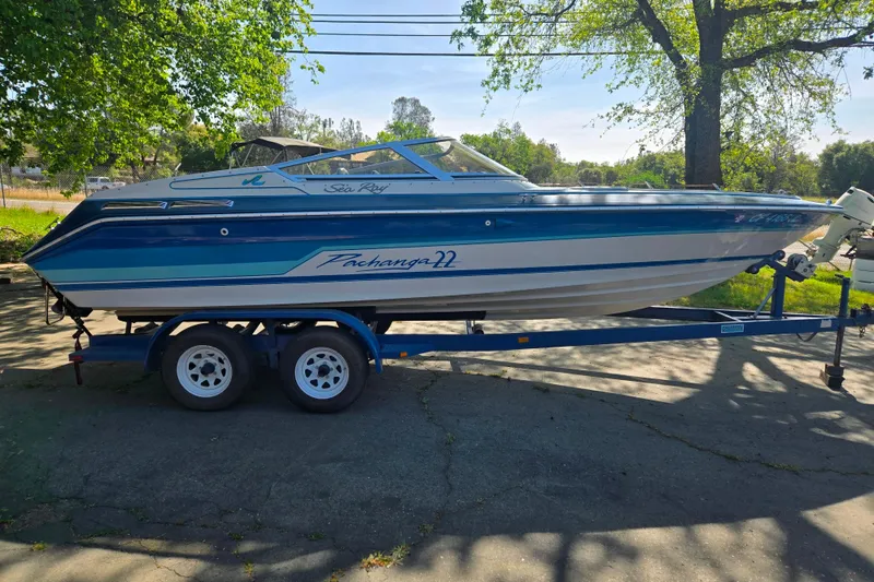 Slide: The Image of 1987 Sea Ray Pachanga 22 boat on trailer, parked outdoors under trees. - 20